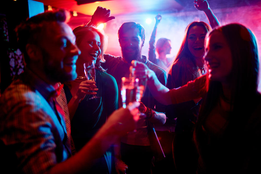 Group,Of,Young,People,Celebrating,With,Drinks,In,Nightclub